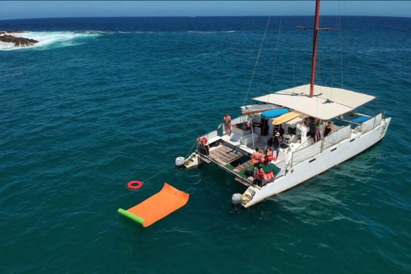 50-foot catamaran at anchor with a floating mat in turquoise water