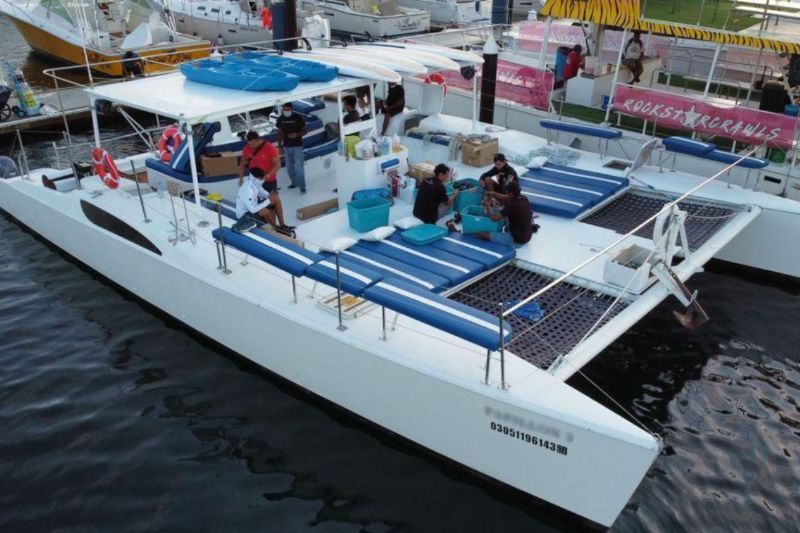 47-foot party catamaran at the dock with blue lounge cushions and trampoline nets
