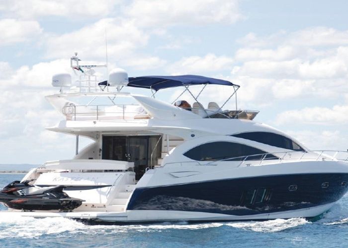 White flybridge yacht cruising at speed