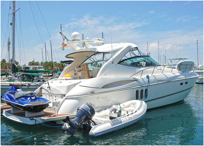 Express cruiser moored in a marina with a jet ski alongside