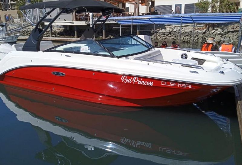 27-foot Sea Ray with a red hull tied up at a marina dock