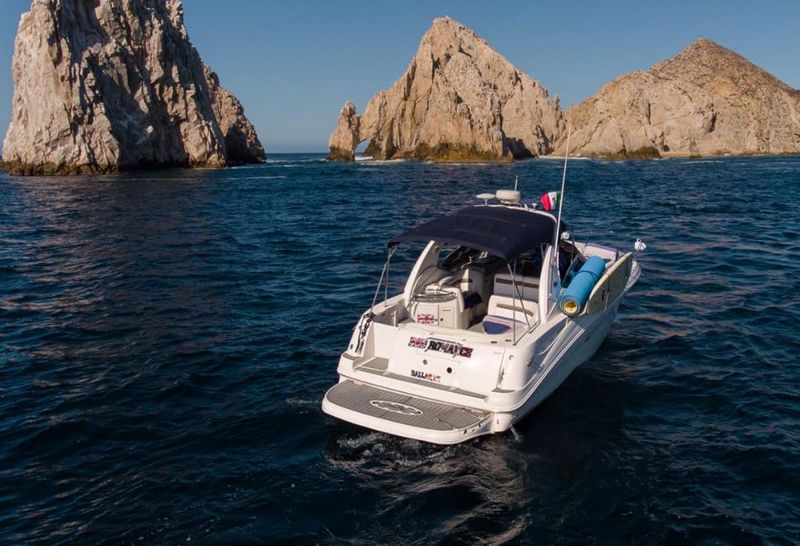 32-foot Sea Ray sport cruiser idling beside the granite pinnacles of Land's End