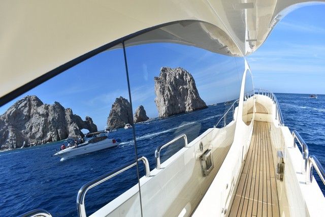 El Arco reflected in the polished window of a yacht cruising past Land's End